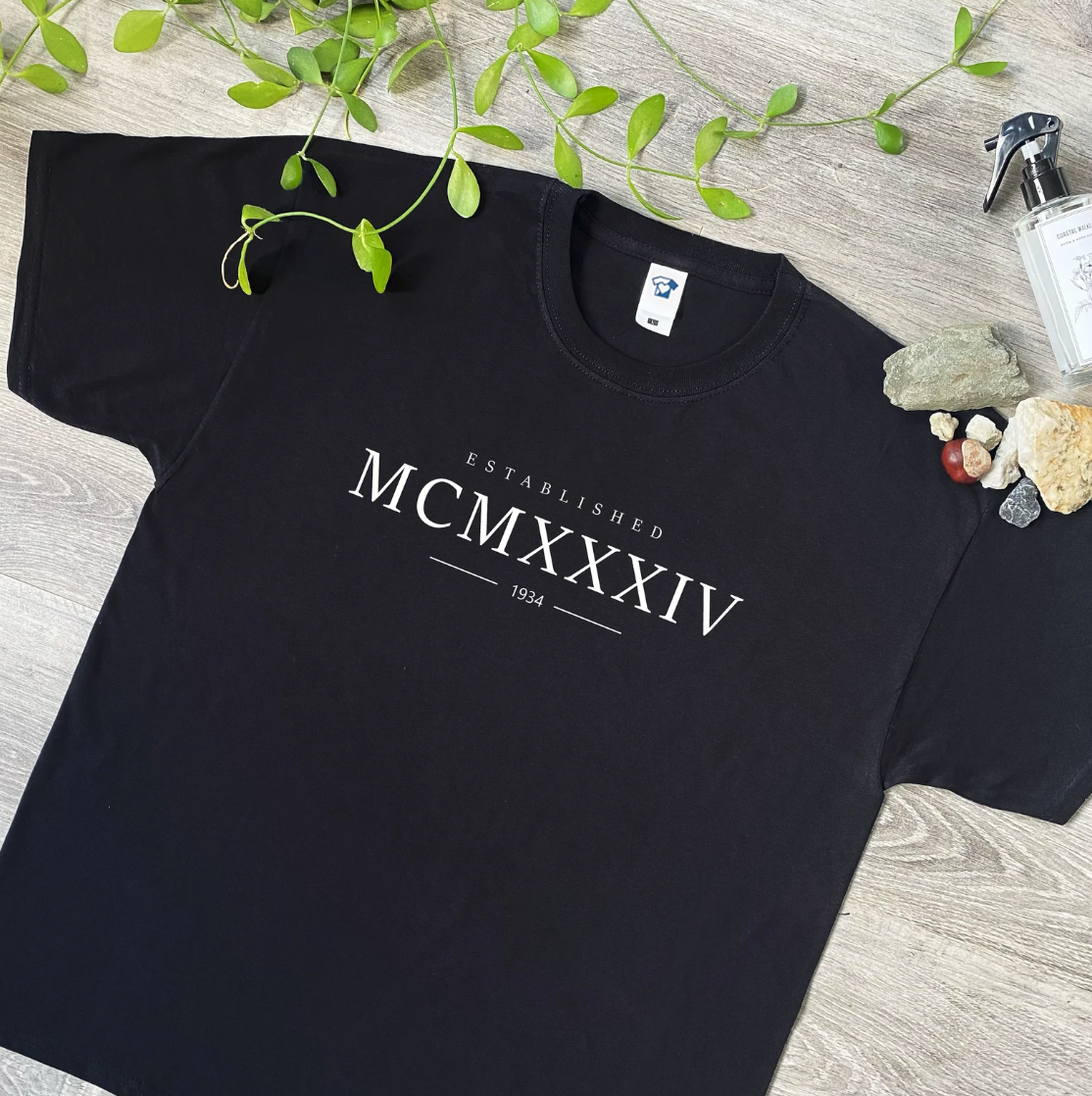 Our Customised Roman Numerals T-Shirt is a stylish way to celebrate a special birth year! Featuring elegant and timeless Roman numerals that represent the year of your choice—like MCMXCV for 1995—this shirt adds a personal touch to any wardrobe. Made from soft, high-quality cotton, it offers all-day comfort, making it perfect for casual outings, birthdays, or as a unique gift for friends and family. Whether you’re celebrating a milestone birthday or just want to showcase your birth year in a chic way, this 